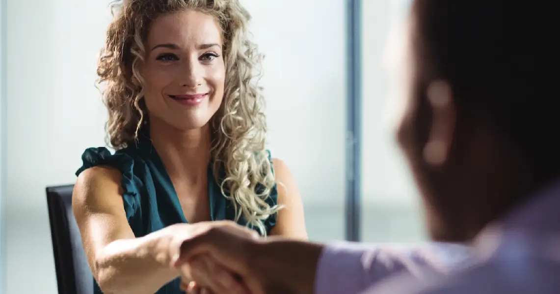 Foto de uma mulher e um homem apertando as mãos